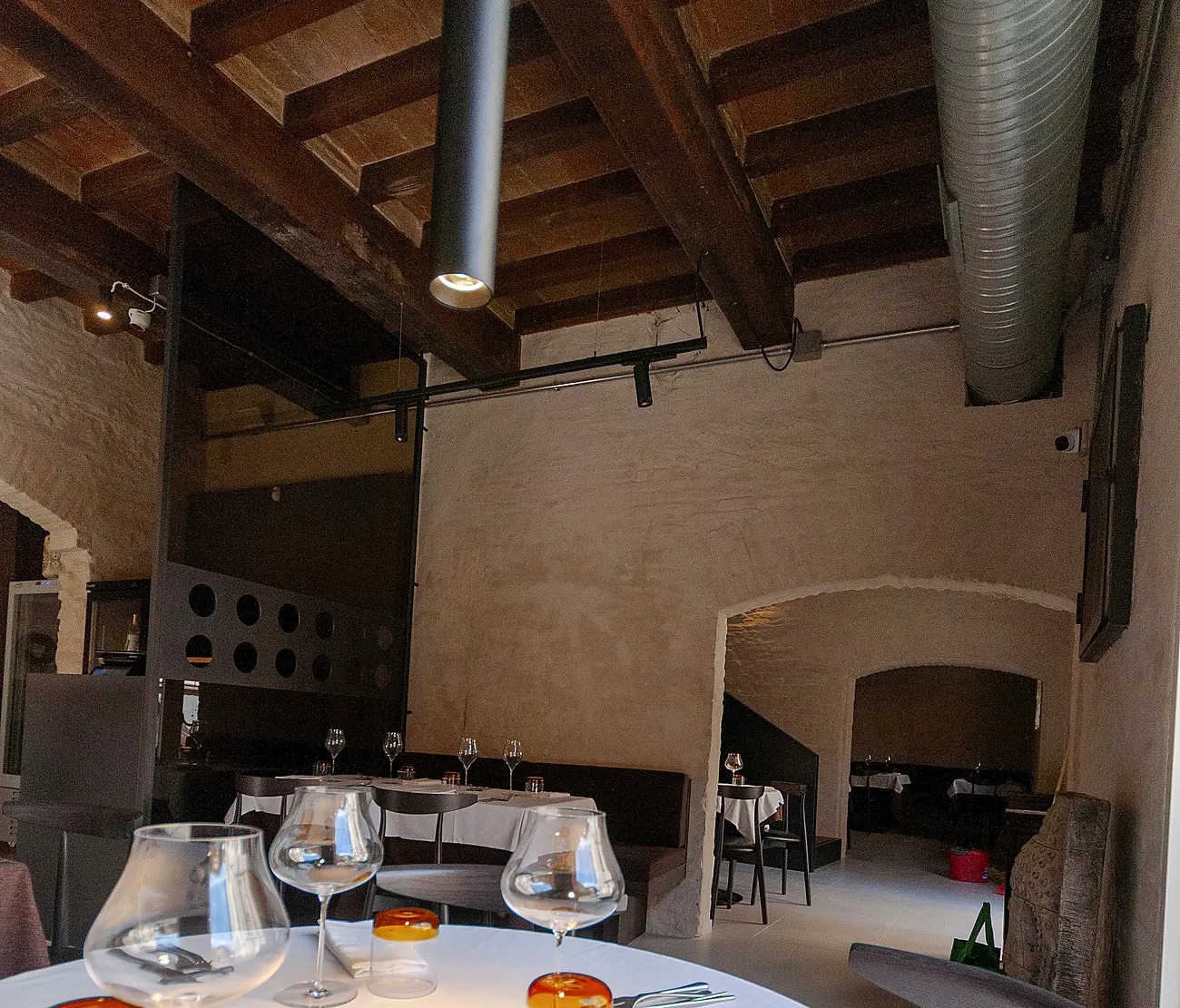 Sala da pranzo di Tao con arco in pietra e travi a vista