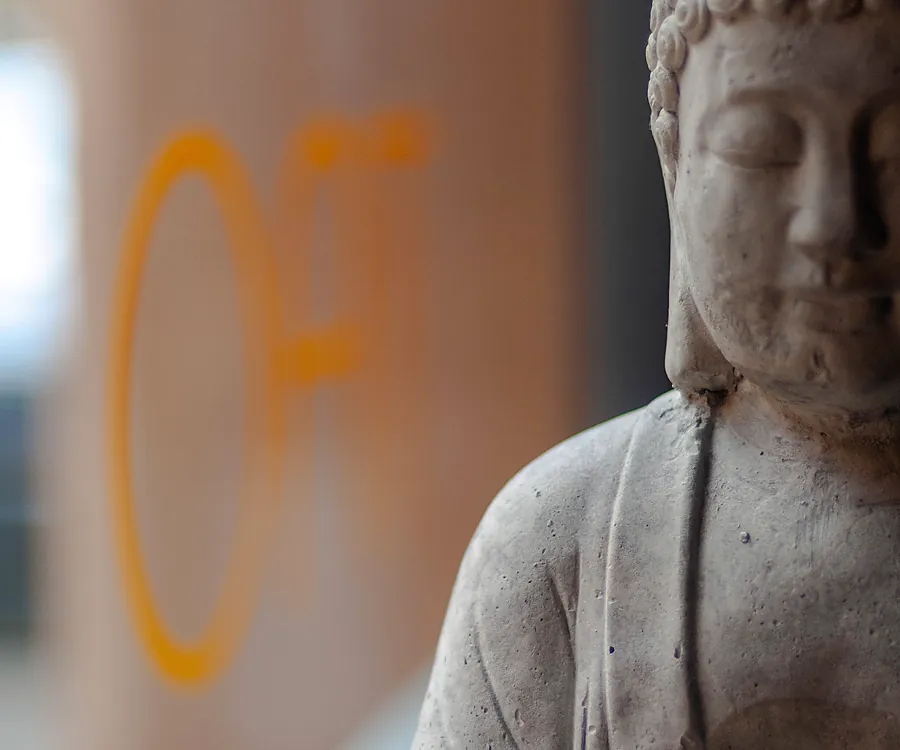 Statua del Buddha e calligrafia orientale alle pareti